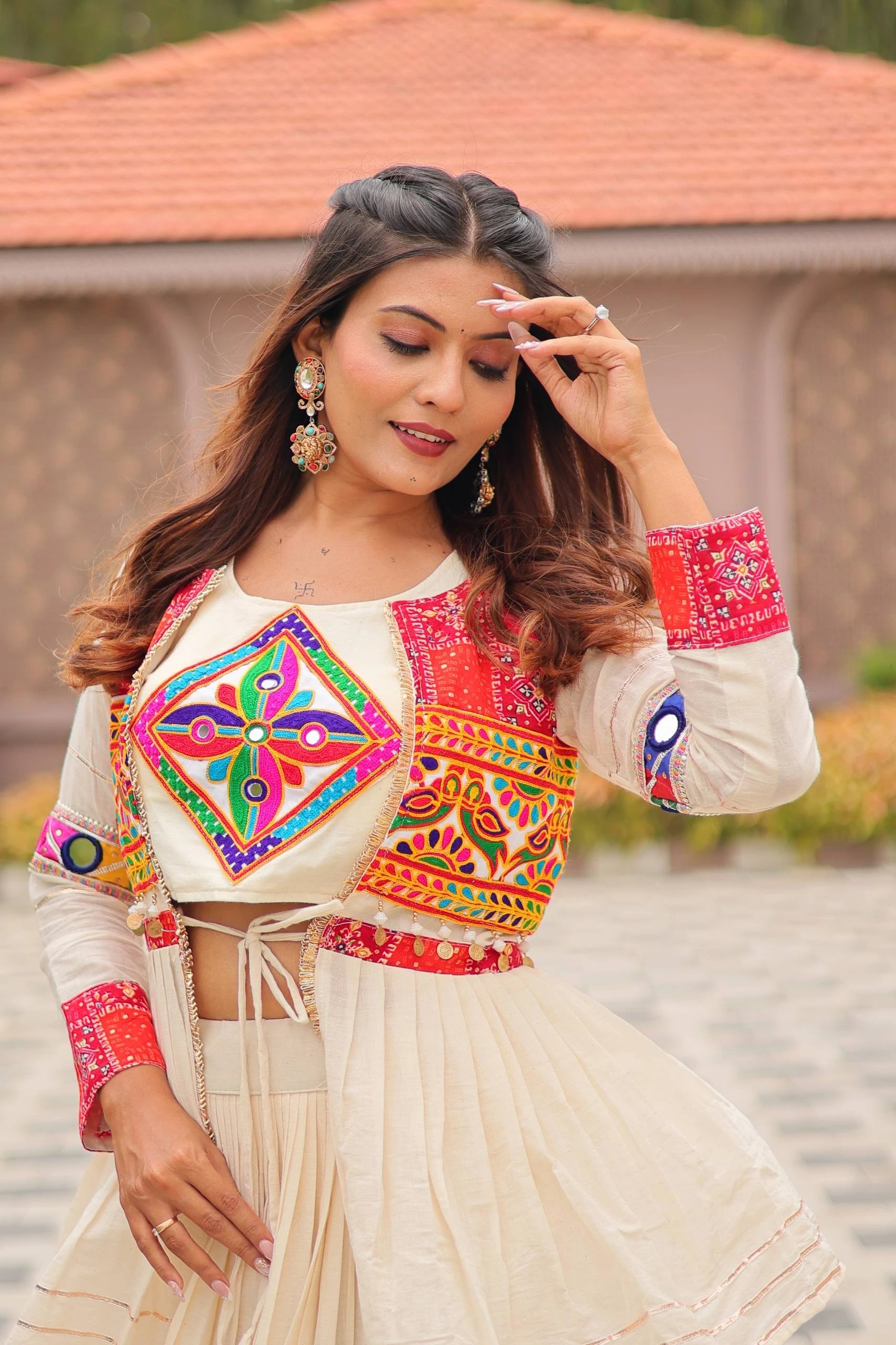 Woman in traditional outfit with colorful embroidery, standing outdoors.